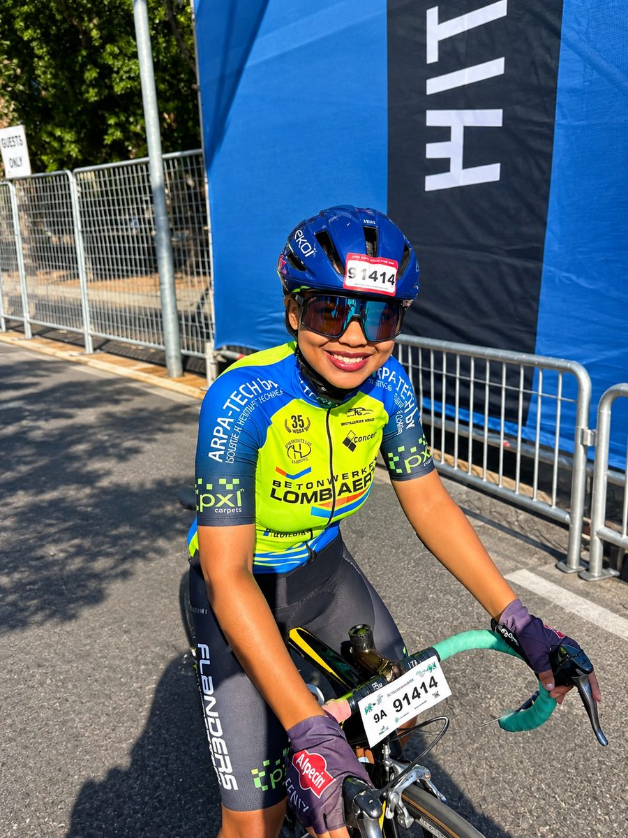 Youth rider smiling at a road race start in the Kinetic kit